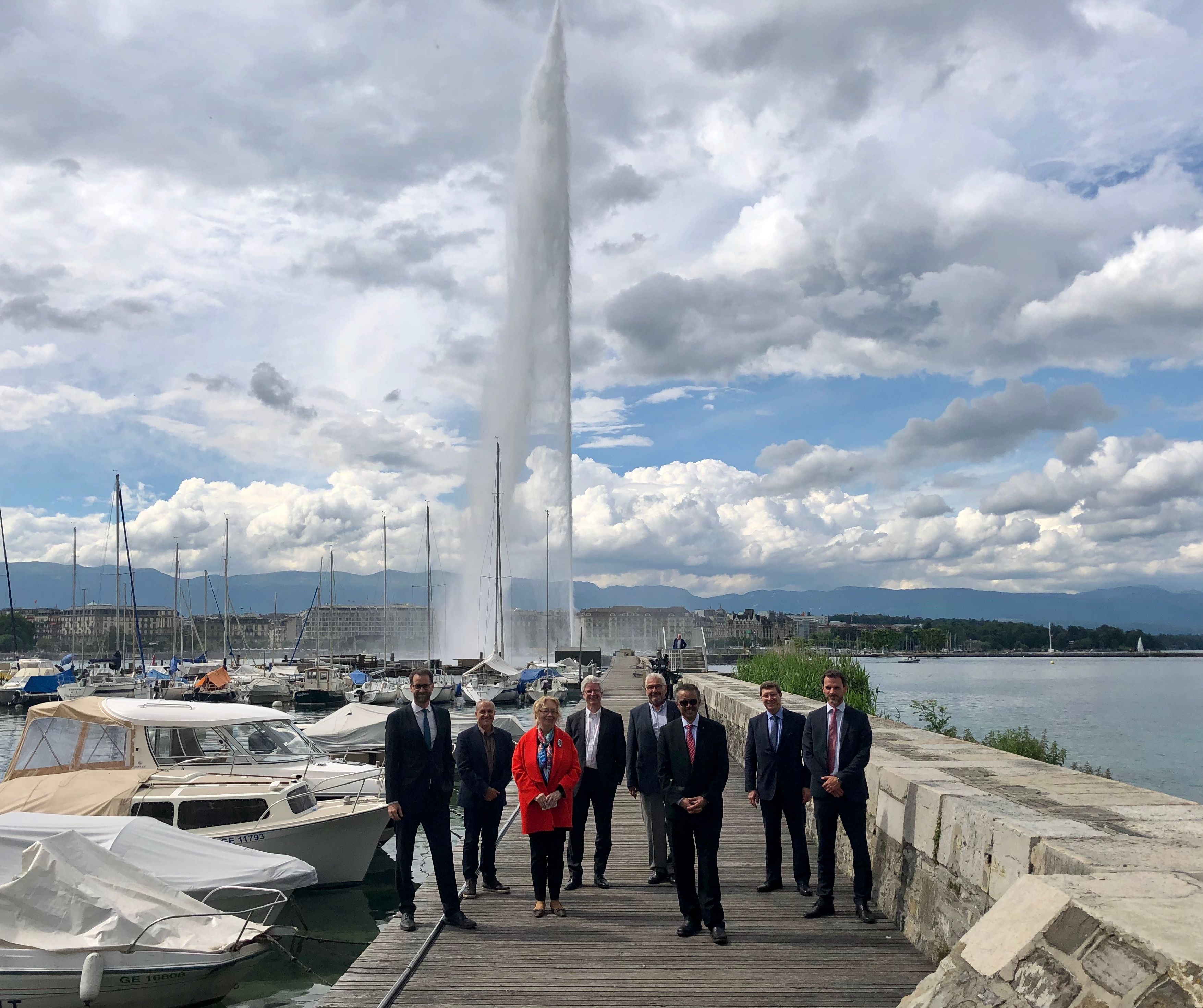 Tedros Adhanom Ghebreyesus, Directeur général de l'OMS et Tatiana Valovaya, Directrice générale de l'ONUG, accompagnés de représentants des autorités locales après le rallumage officiel du Jet d'eau